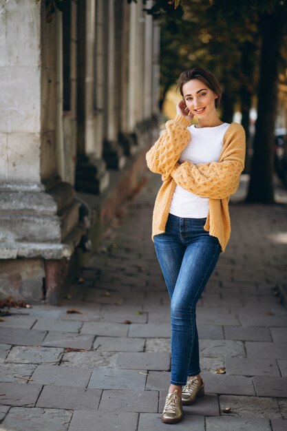 Vrouw in warme doeken buiten in de herfstpark