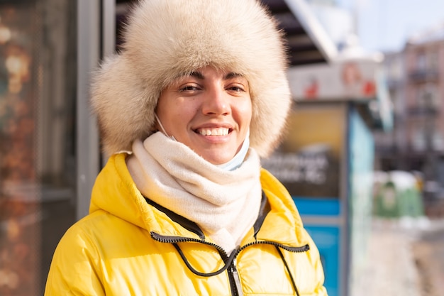 Vrouw in winterkleren op een koude dag te wachten op een bus bij een bushalte