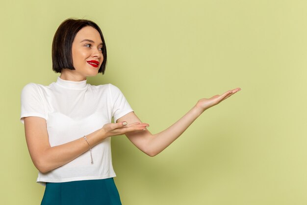 vrouw in witte blouse en groene rok poseren met een glimlach