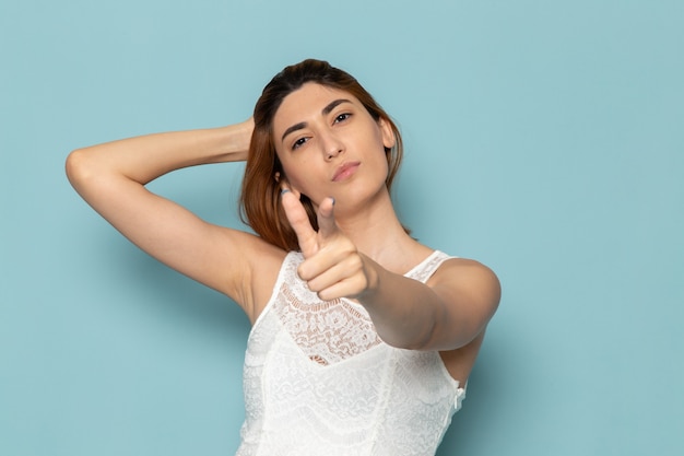 vrouw in witte jurk poseren en wijzen op mode dame kleur