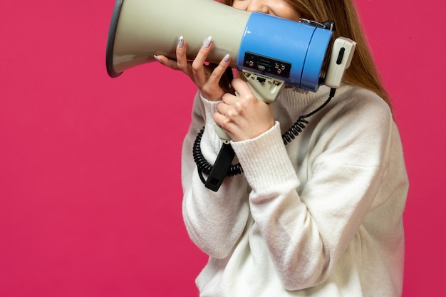 Gratis foto vrouw in witte trui met luidspreker