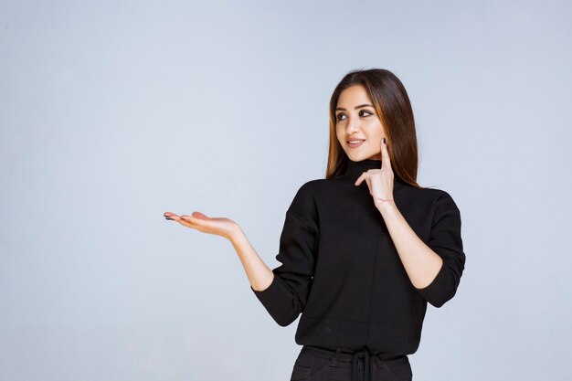 vrouw in zwart shirt ziet er attent uit.