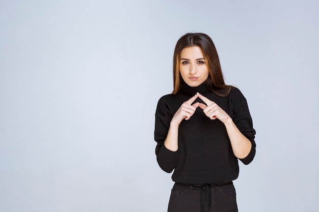 Vrouw in zwart shirt ziet er verward en attent uit.