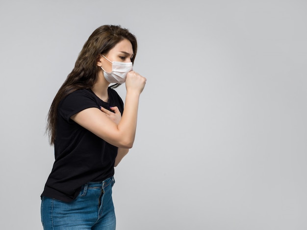 Vrouw in zwart t-shirt en spijkerbroek hoesten