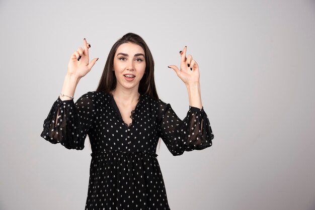 Vrouw in zwarte jurk die borden maakt met haar handen.