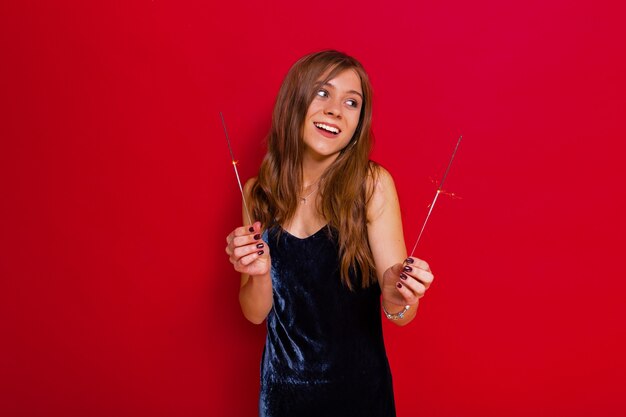 Vrouw in zwarte jurk met fakkels op rood