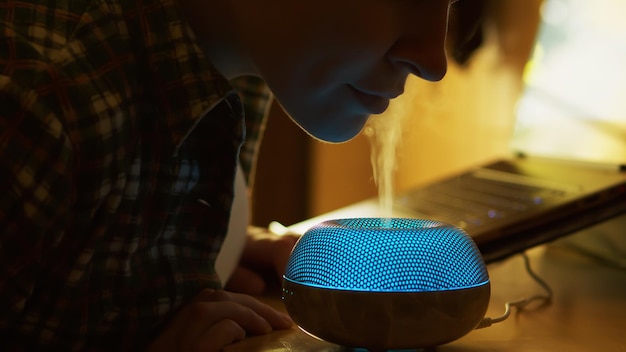 Gratis foto vrouw inhaleert aromatische damp van etherische oliediffuser terwijl ze in de keuken werkt