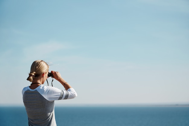 Gratis foto vrouw kijkt door een verrekijker