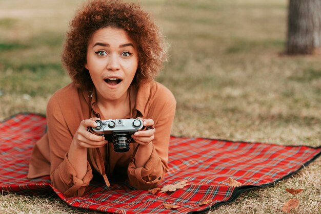 Vrouw kijkt geschokt terwijl ze een camera vasthoudt