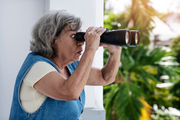 Vrouw kijkt naar buiten met een verrekijker