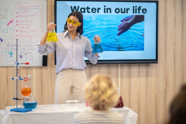 Vrouw kijkt naar laboratoriumfles in de hand