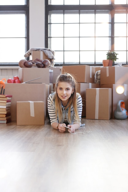 Gratis foto vrouw klaar met lading pakketten en ligt op de vloer