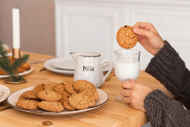 Vrouw koekje in melk onderdompelen