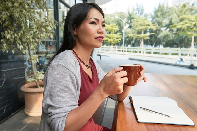 Vrouw koffie drinken in café