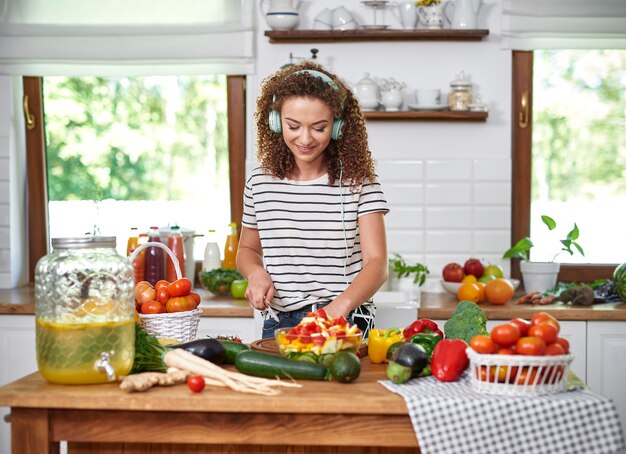 Vrouw koken en naar muziek luisteren