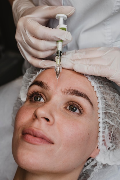 Vrouw krijgt een gezichtsschoonheidsinjectie in het wellnesscentrum