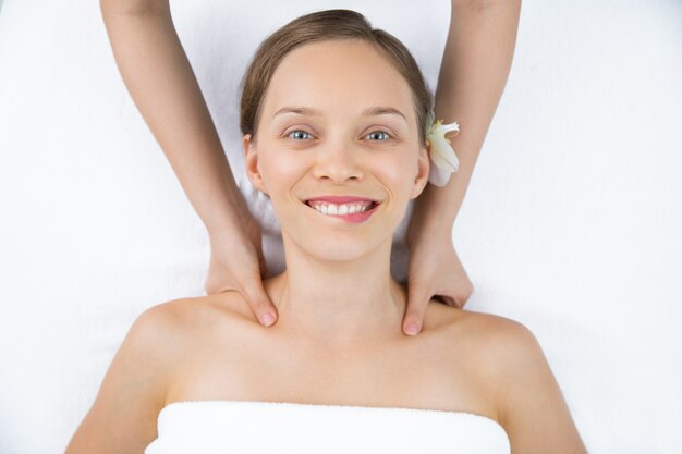 Vrouw krijgt een massage op de schouders van bovenaf gezien
