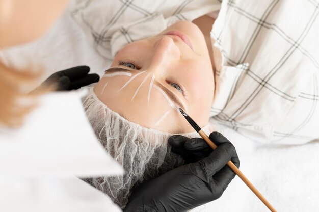 Vrouw krijgt een wenkbrauwbehandeling bij de schoonheidssalon