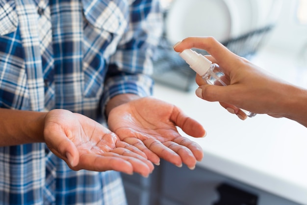 Vrouw krijgt hulp met handdesinfecterend middel van vriend