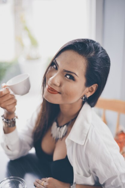 Vrouw lachend met een kopje koffie