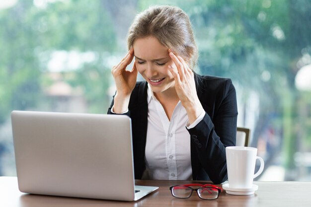 Vrouw lachend te kijken naar een laptop