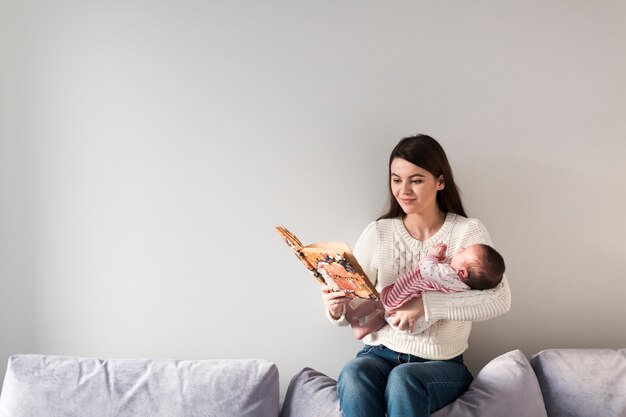 Vrouw leesboek en kind te houden