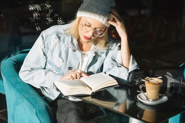 Vrouw leesboek in café