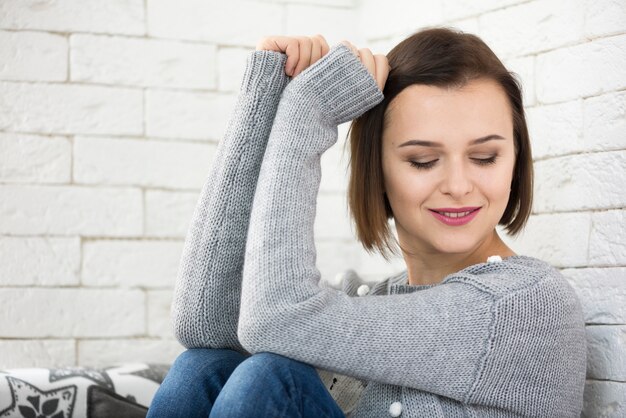 Vrouw leunend op de muur thuis