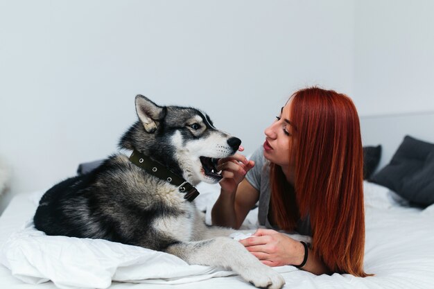 Vrouw liggend met hond op bed