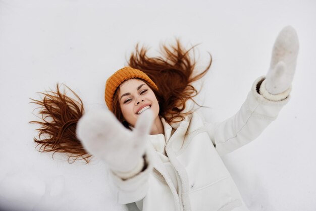 Vrouw ligt op de sneeuw plezier rust natuur er is veel sneeuw in de buurt hoge kwaliteit foto Premium Foto