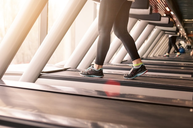 Gratis foto vrouw loopt in een sportschool op een loopband-concept voor training, fitness en een gezonde levensstijl