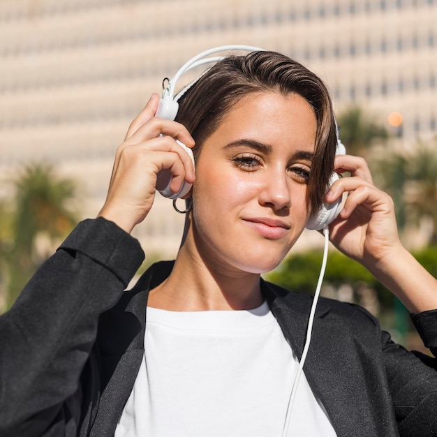 Vrouw luisteren naar muziek op koptelefoon buitenshuis