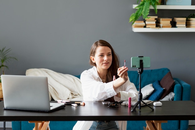 Gratis foto vrouw maakt beauty vlog met haar smartphone