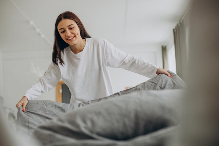 Gratis Foto vrouw maakt haar bed na het slapen in de ochtend