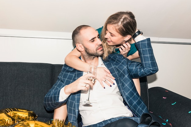 Vrouw man van achteren knuffelen op feestje