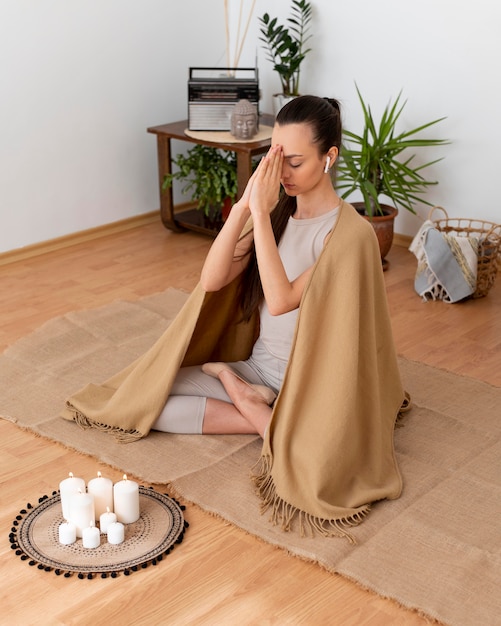 Vrouw mediteren met dienblad met kaarsen