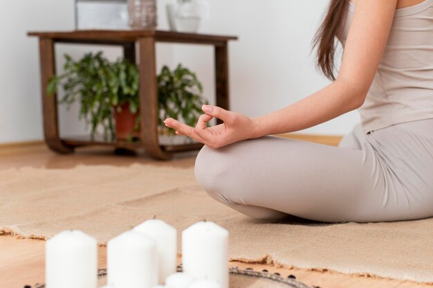 Vrouw mediteren met dienblad met kaarsen