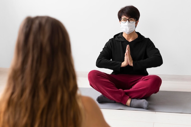 Vrouw mediteren met een gezichtsmasker op