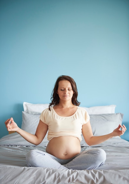 Gratis foto vrouw mediteren tijdens de zwangerschap