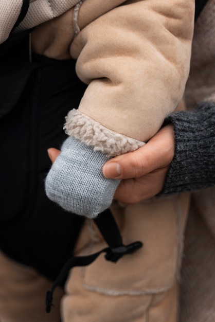 Gratis foto vrouw met baby in drager zijaanzicht