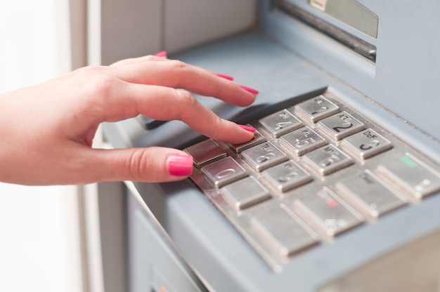 Vrouw met behulp van bankautomaat. Detailopname