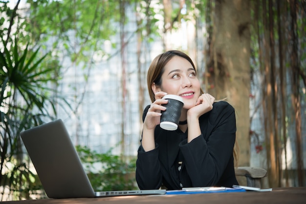 Vrouw met behulp van computer glimlach koffie