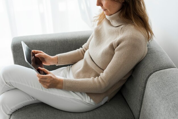 Vrouw met behulp van digitale tablet op een bank