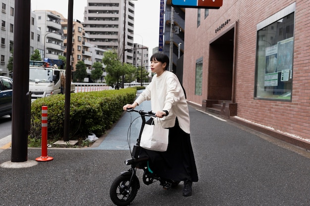 Vrouw met behulp van elektrische fiets in de stad