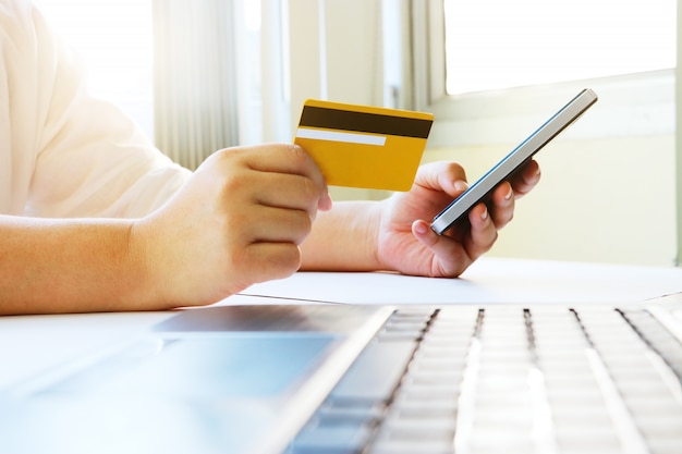 Vrouw met behulp van mobiele telefoon om online winkelen en te betalen met credit ca