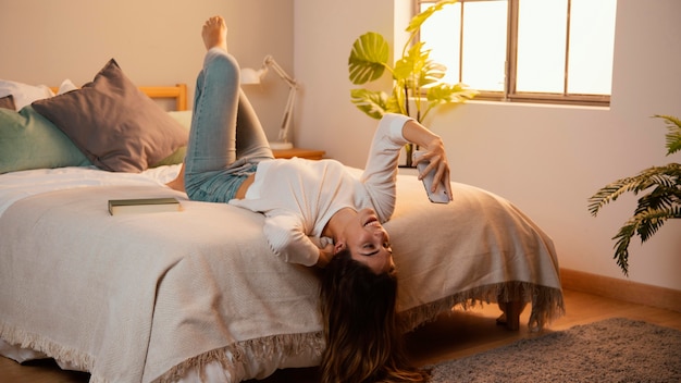 Vrouw met behulp van smartphone thuis in bed