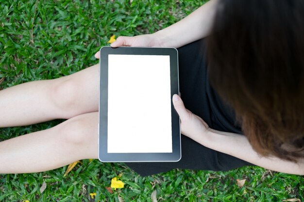 Vrouw met behulp van tablet in de tuin