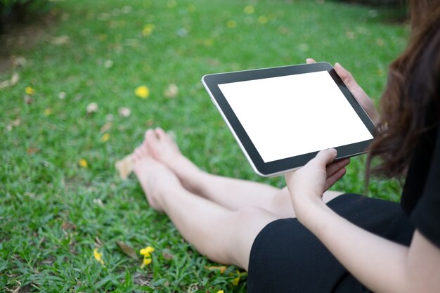 Vrouw met behulp van tablet in de tuin