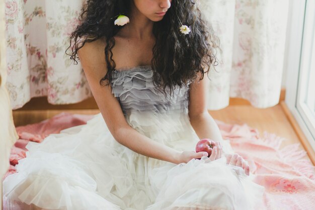 Vrouw met bloemen en appel bijsnijden