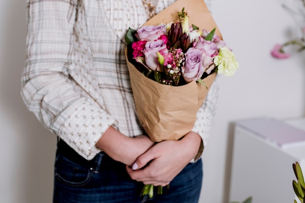 Vrouw met boeket bloemen in de winkel